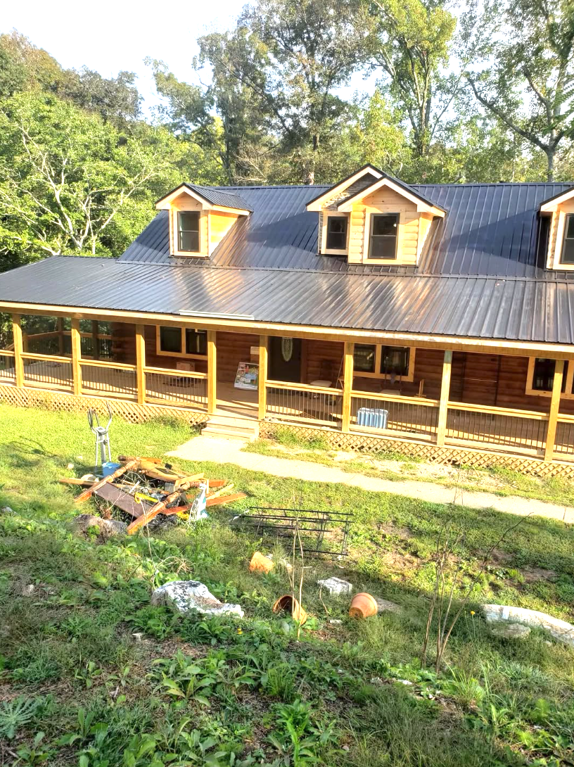 Completed dark metal roof on a log cabin